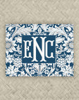 A NMJL Mahjong card cover sticker with a navy blue and white floral damask pattern along the border, personalized with a three-letter monogram in white serif letters against a navy blue background.