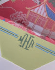 Video showing stationery set that includes a green notecard with monogram on front and a white envelop with return address on the flap and a red chinoserie print lining that features a pagoda design.